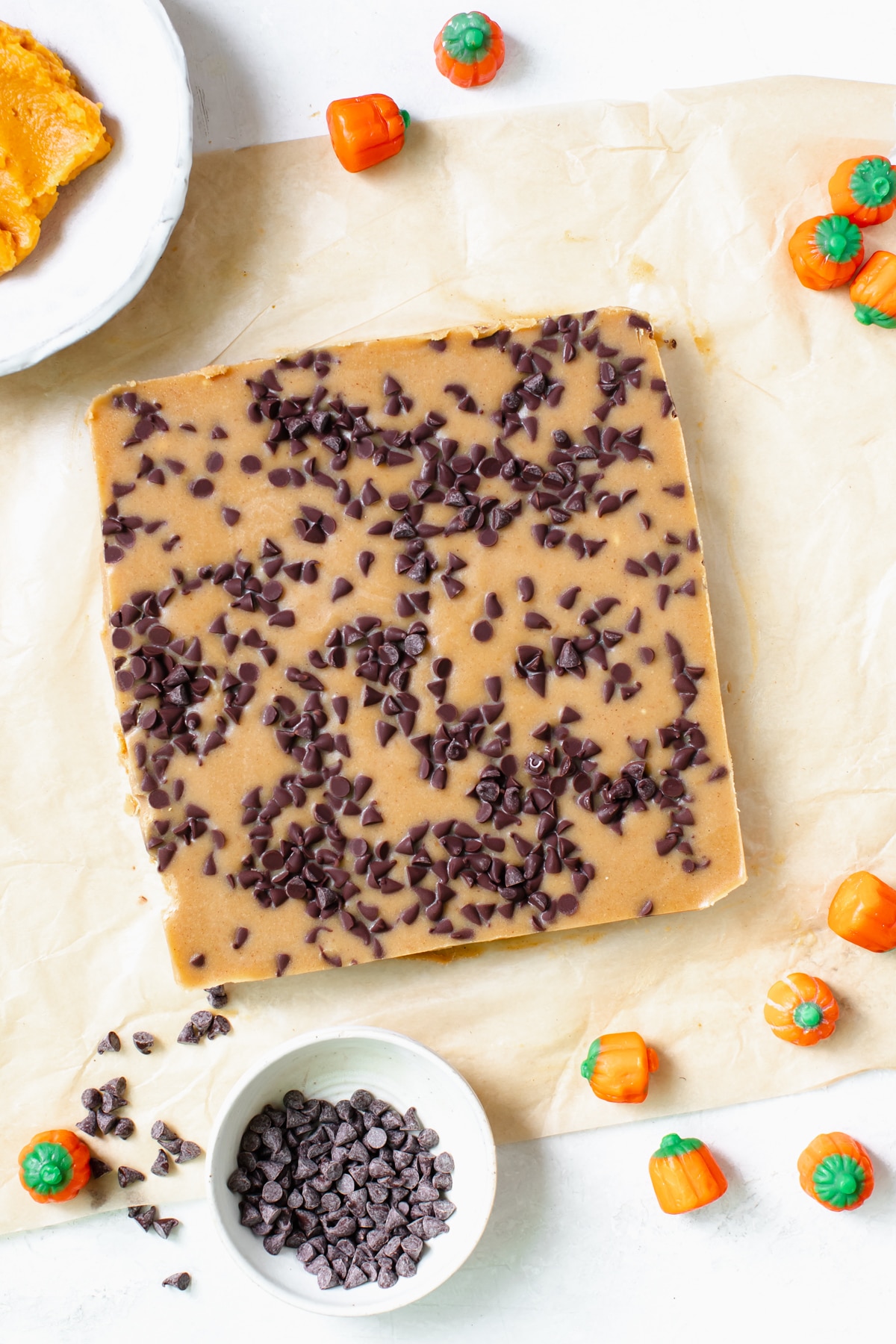 pumpkin candy freezer fudge on parchment paper coated in mini chocolate chips