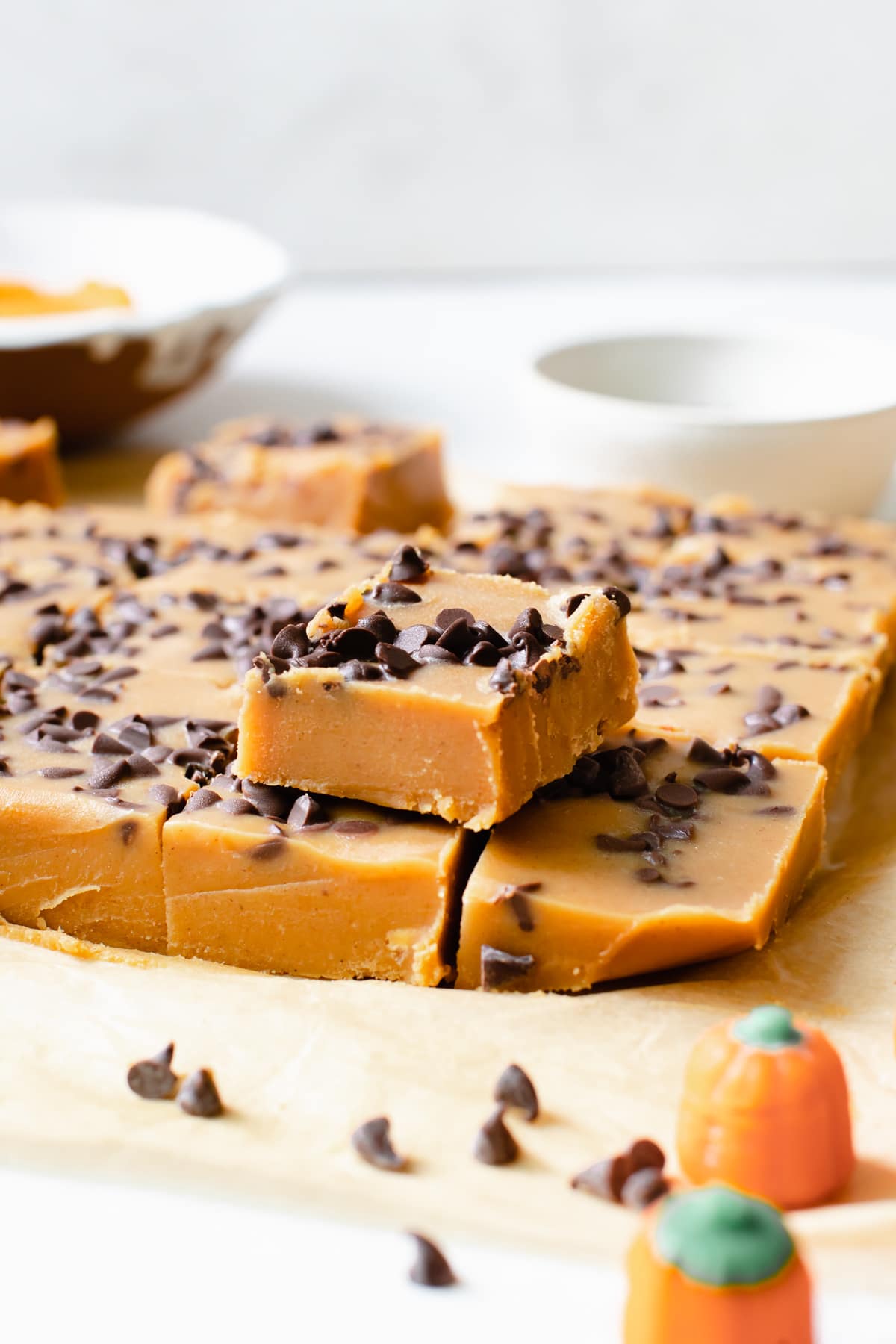 pumpkin candy fudge on parchment paper coated in mini chocolate chips cut into squares