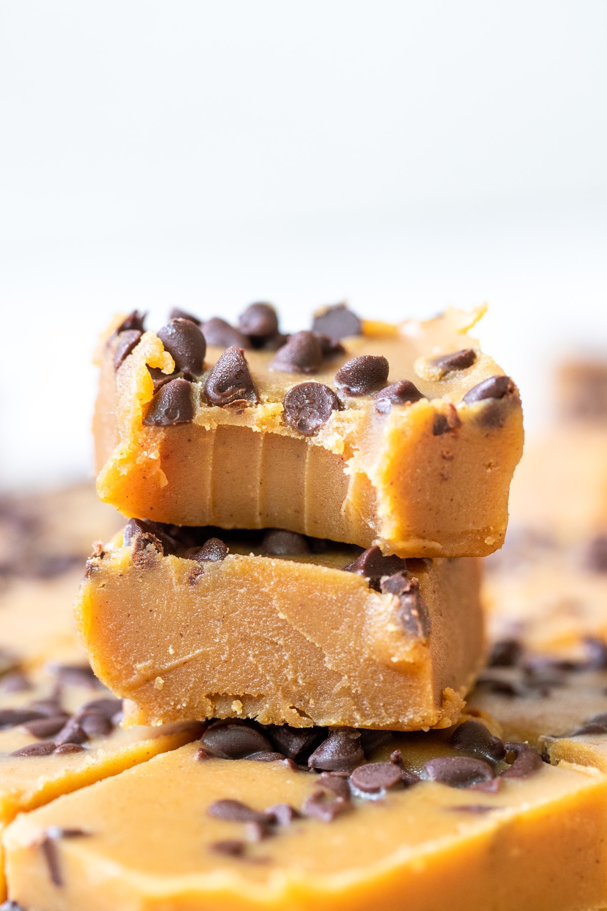 pumpkin candy fudge on parchment paper coated in mini chocolate chips cut into squares