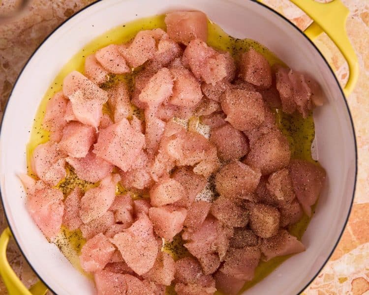 dutch oven pot with cubed raw chicken breast.