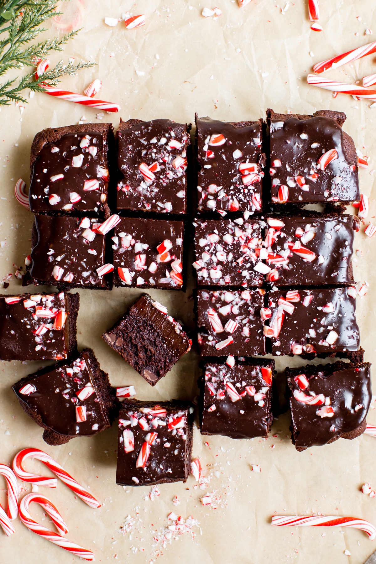 brownies made with peppermint on brown parchment paper and topped with crushed candy canes