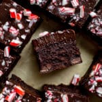 brownies cut into squares topped with chocolate ganache and chopped candy canes