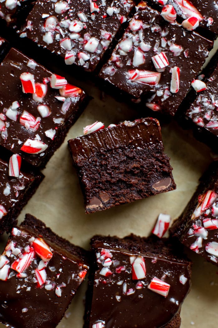 brownies cut into squares topped with chocolate ganache and chopped candy canes