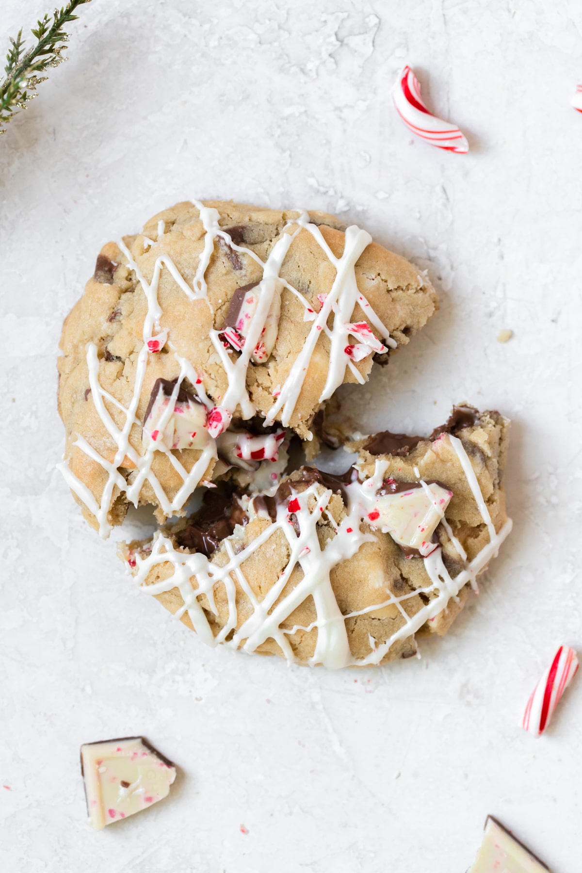 a photo of a giant cookie studded with peppermint bark and drizzled with melted white chocolate