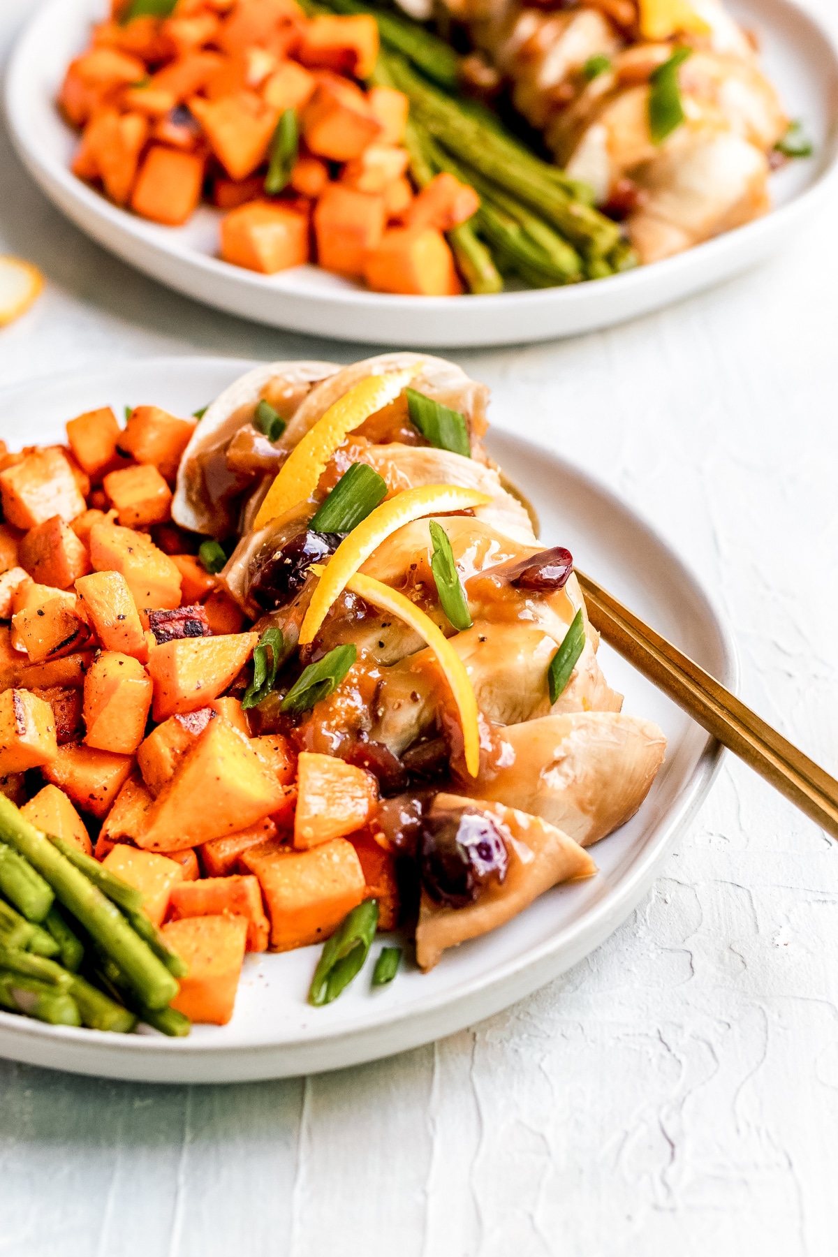 chicken breast made with dried cranberries and dried apricots on a white plate