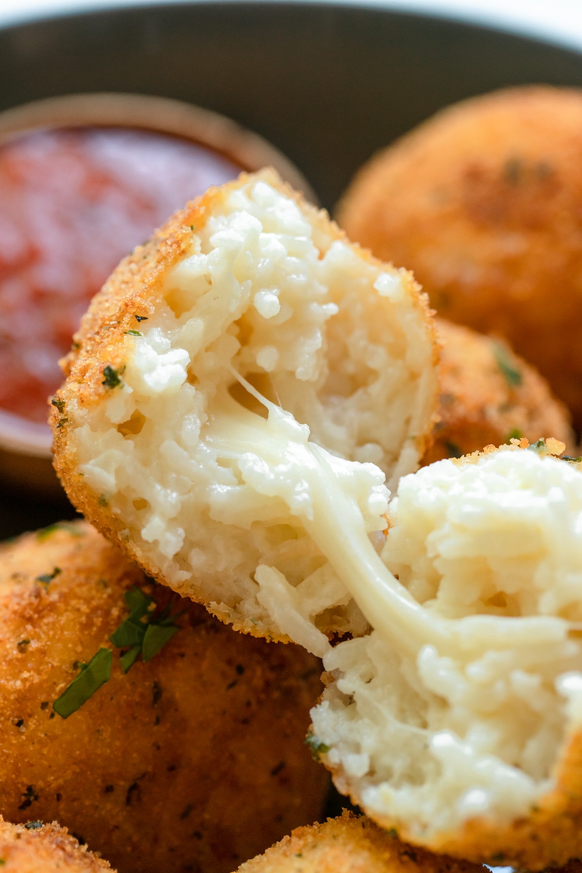 an up close image of the middle of an arancini ball with gooey mozzarella in the center