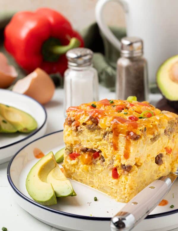 piece of slow cooker breakfast casserole on plate with fork and slice of avocado