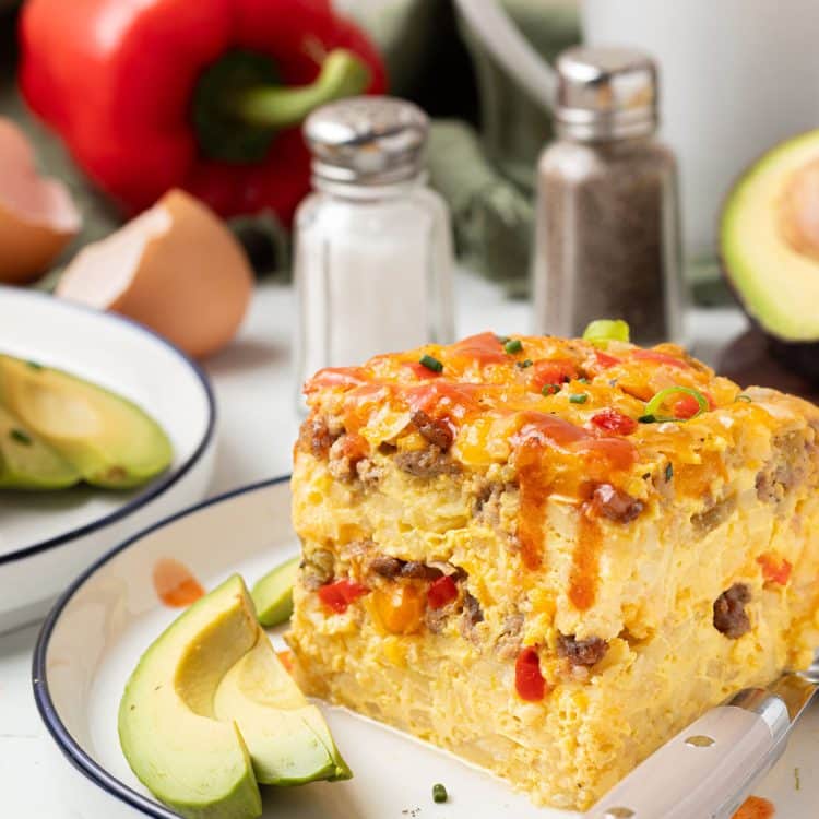 piece of slow cooker breakfast casserole on plate with fork and slice of avocado