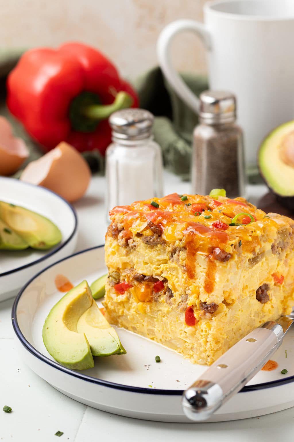 piece of slow cooker breakfast casserole on plate with fork and slice of avocado