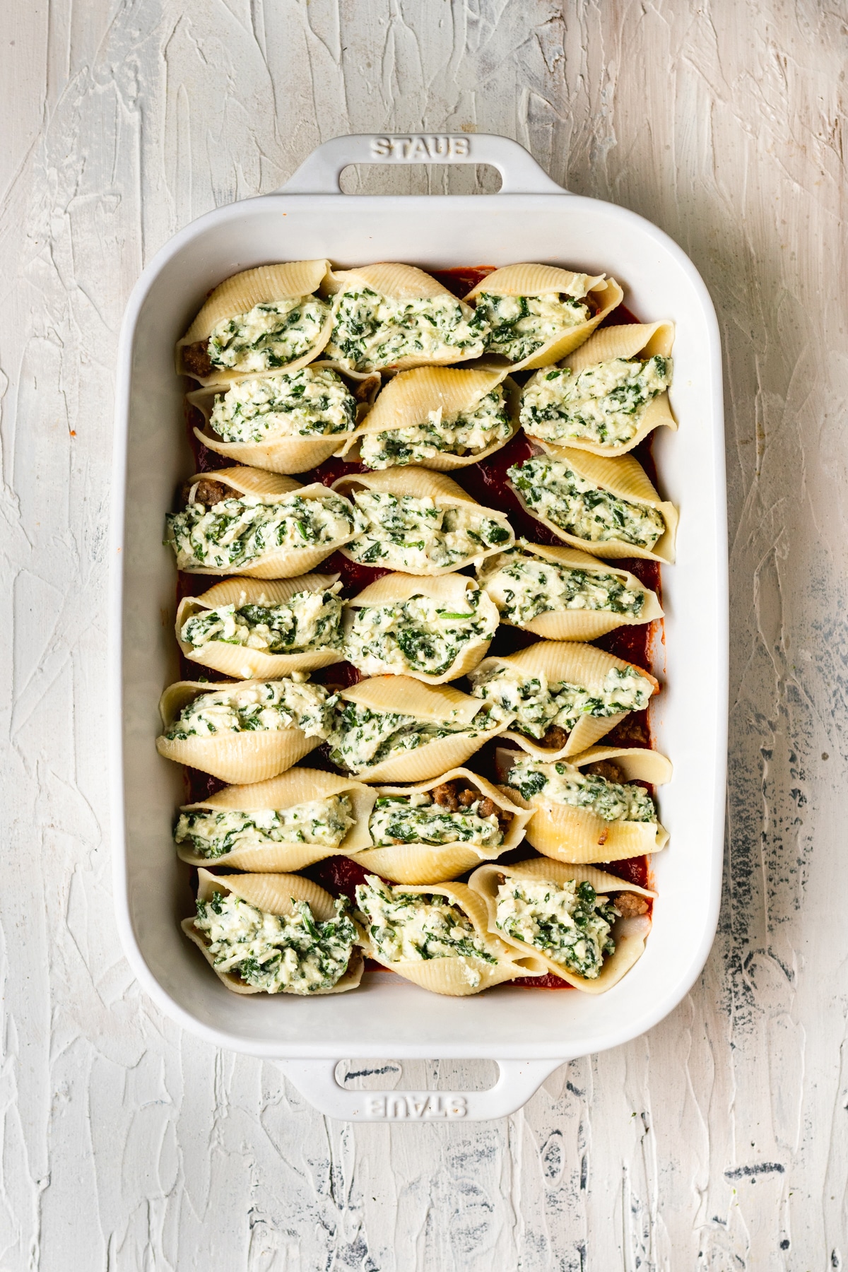 shells filled with cheese in a casserole dish