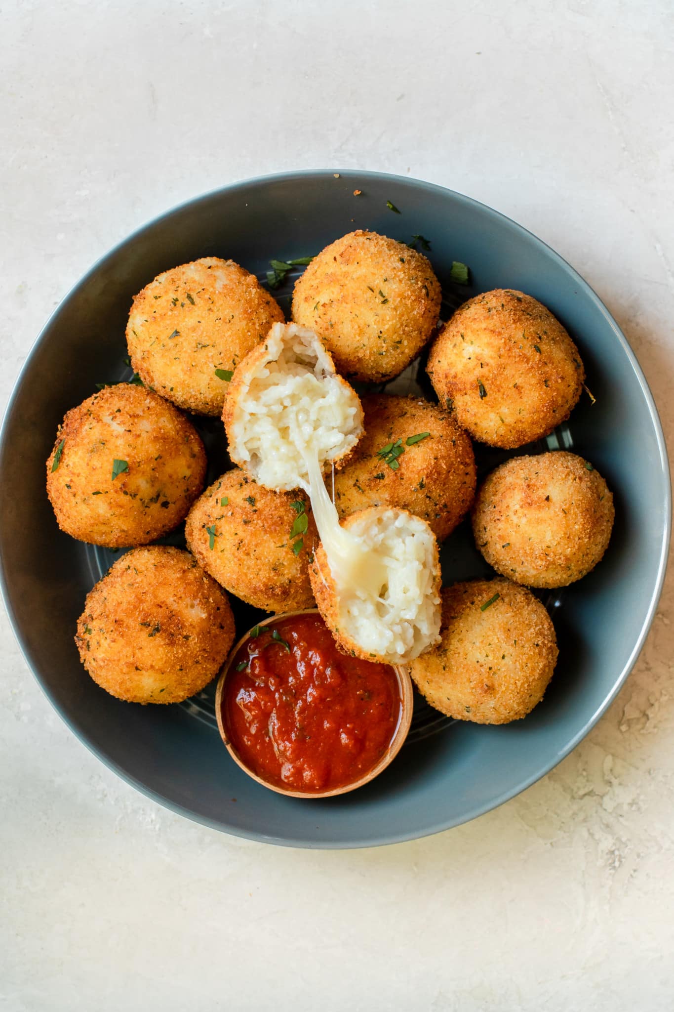 fried rice formed into balls on a blue plate with marinara 