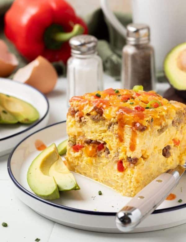 piece of slow cooker breakfast casserole on plate with fork and slice of avocado