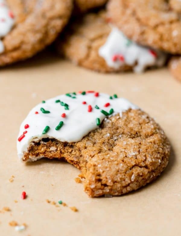 molasses cookies covered in sanding sugar on parchment paper dipped in white chocolate