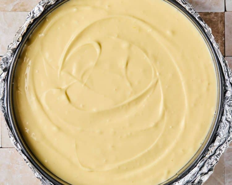 Cheesecake filling in a round pie pan lined with foil.