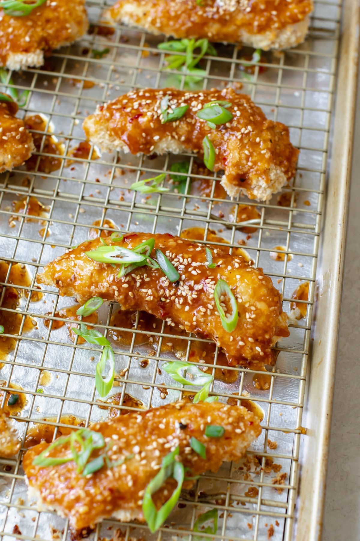 chicken tenders on a baking sheet lined with foil topped with green onions