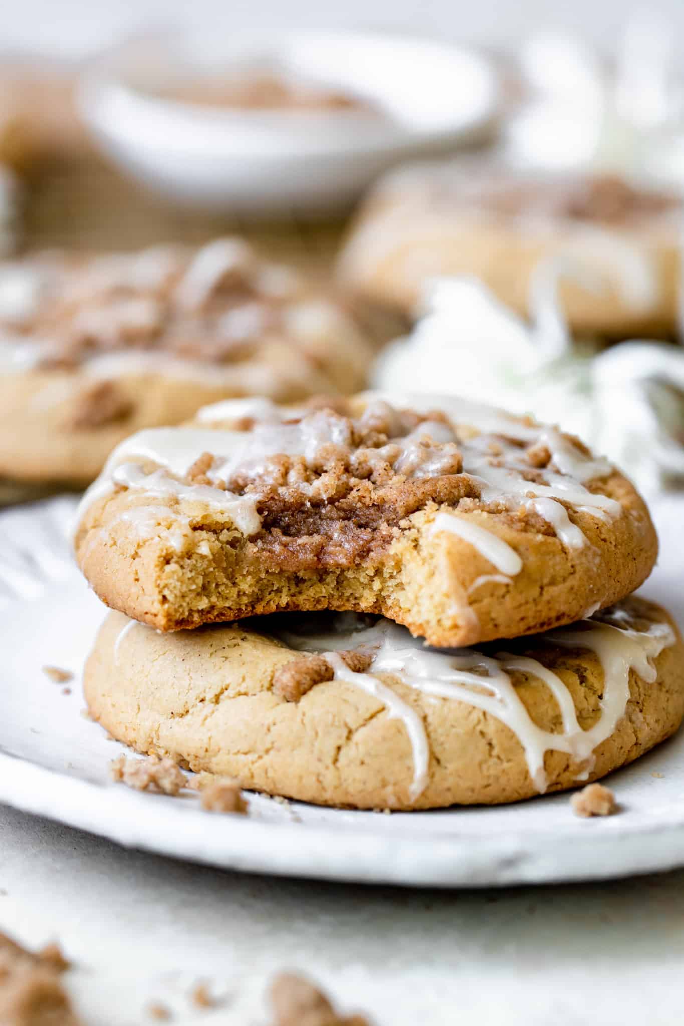 cookies stacked on top of each other on a white plate with coffee cake streusel filling and vanilla icing on top