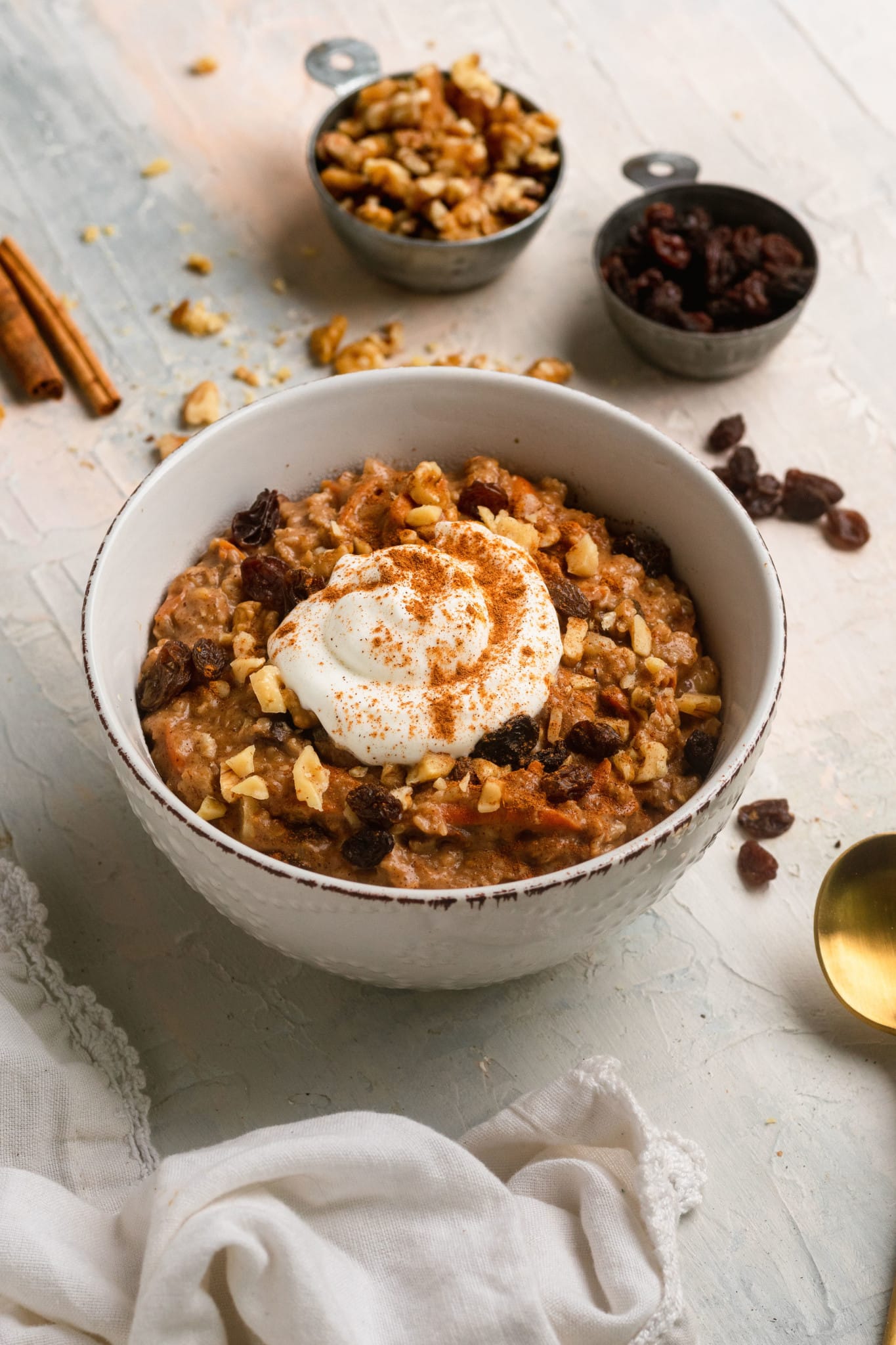 carrot cake oatmeal in a bowl topped with Greek yogurt and cinnamon