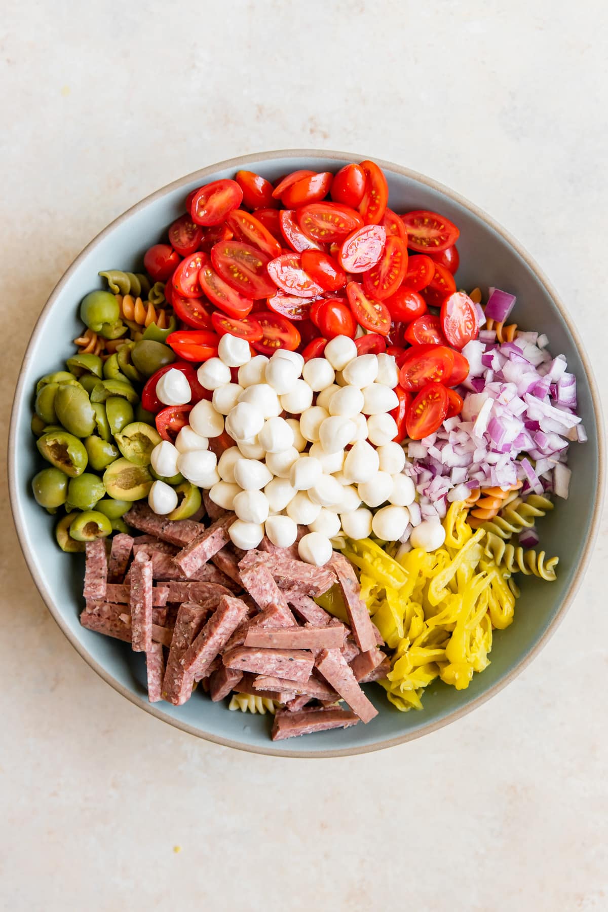 pasta salad ingredients in a large blue bowl. 