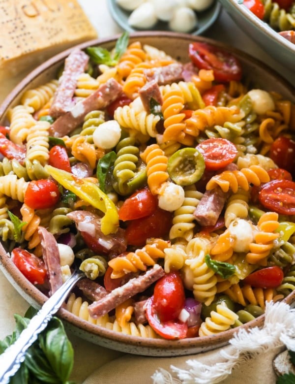 pasta in a bowl with sausage and tomatoes and cheese.