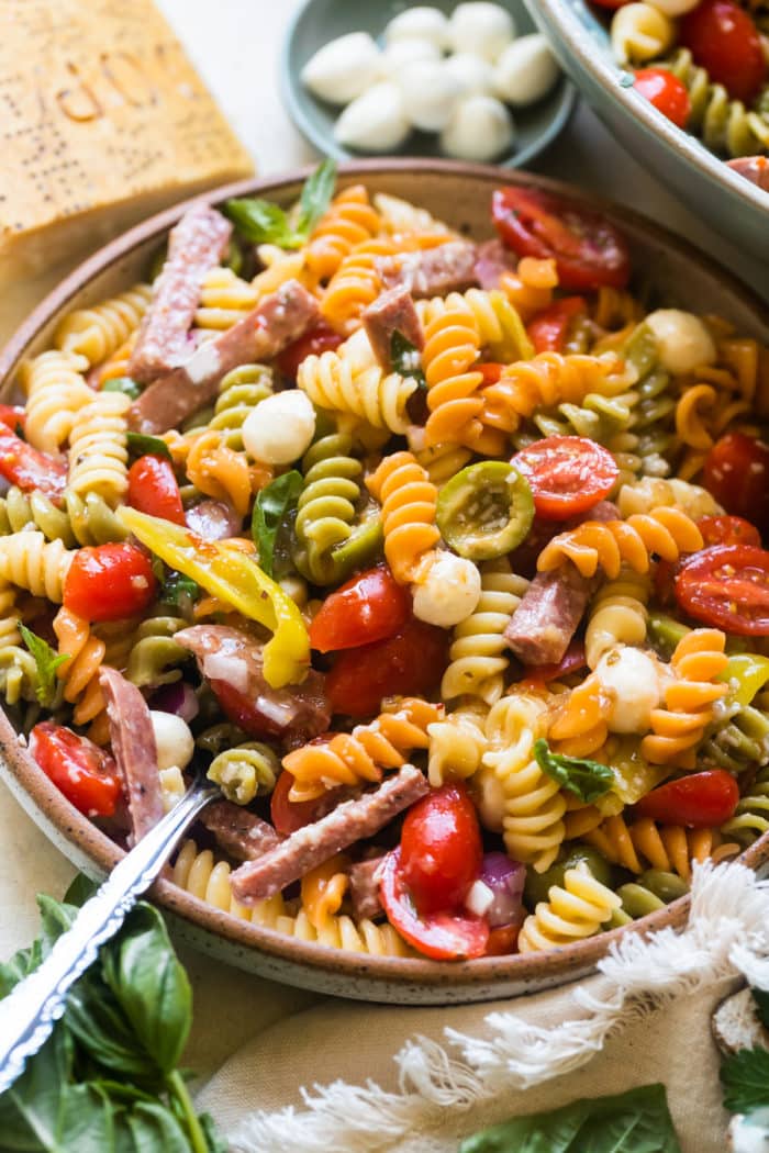 pasta in a bowl with sausage and tomatoes and cheese.