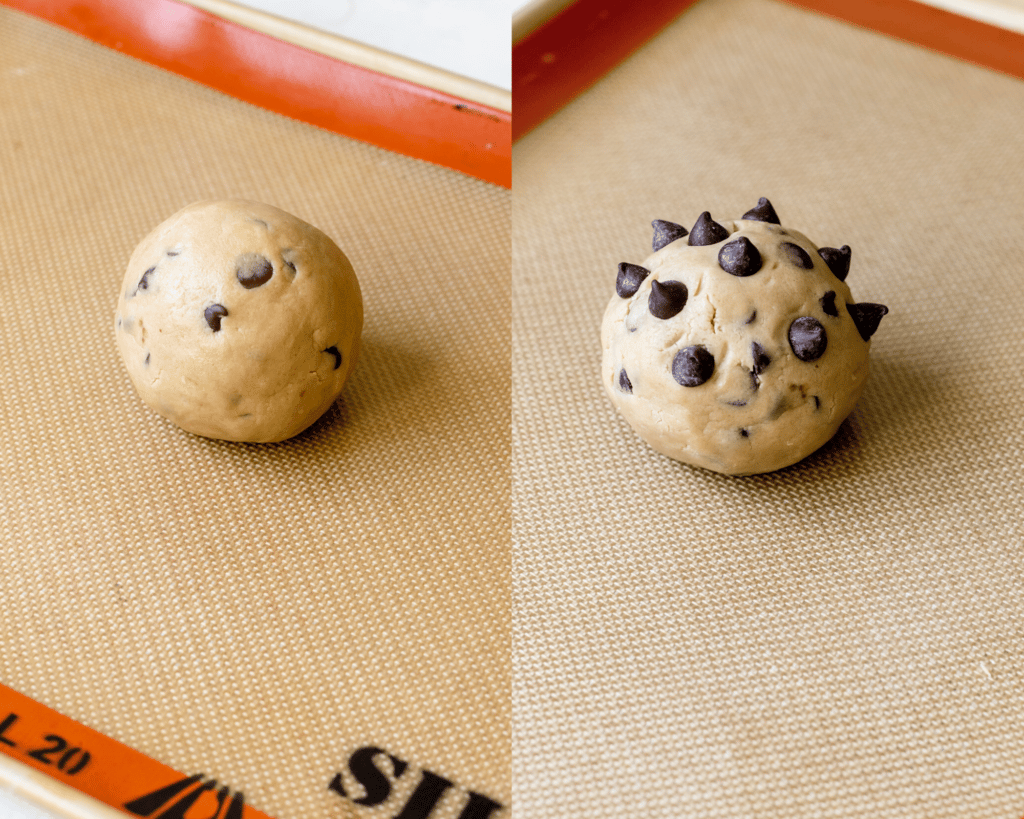 a cookie dough ball on a baking sheet topped with chocolate chips.