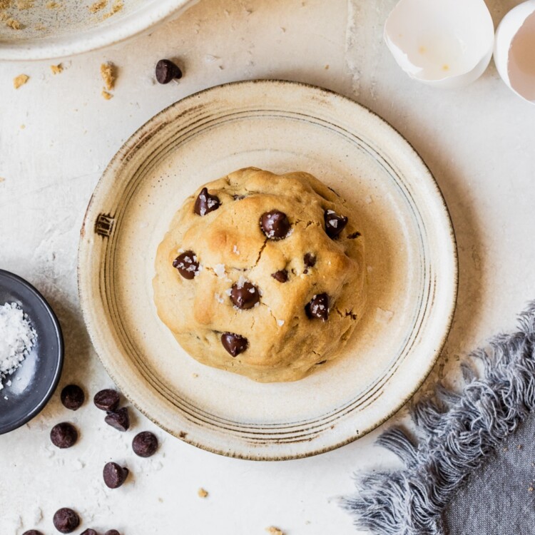 a cookie on a plate topped with flaky sea salt.