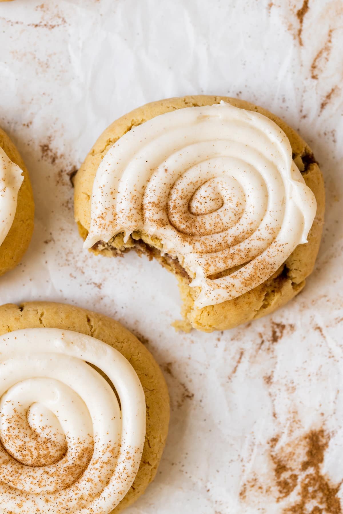 a bite taken out of a cookie that is topped with frosting.