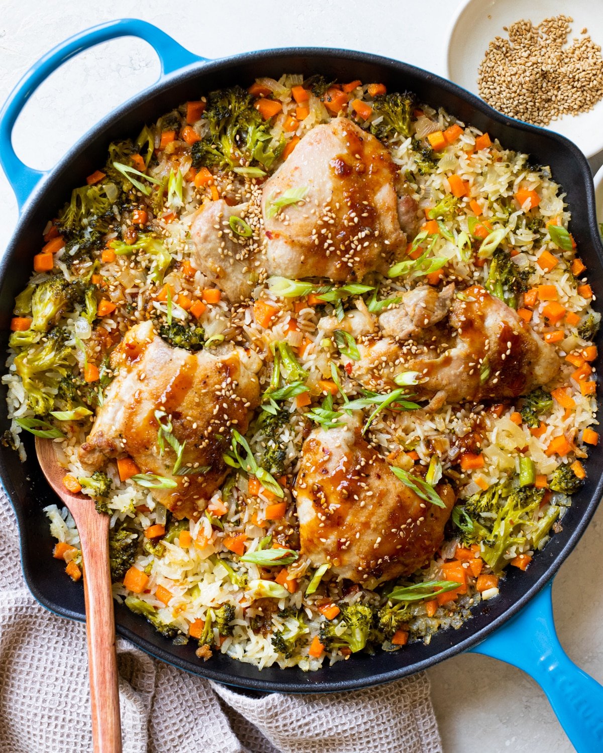 chicken and rice with teriyaki sauce, sesame seeds and green onions on top.