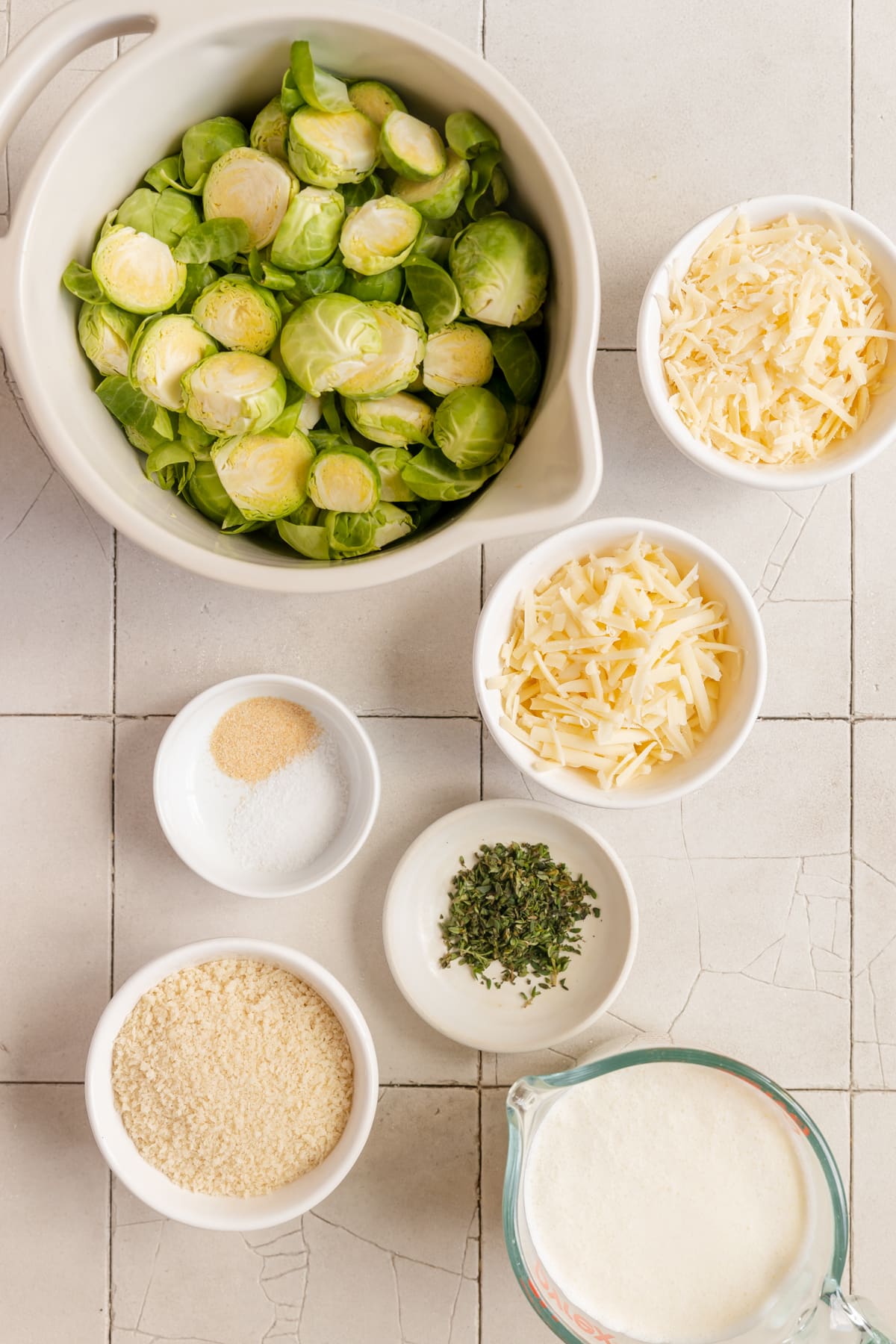 ingredients to make au gratin Brussels in small white bowls. 