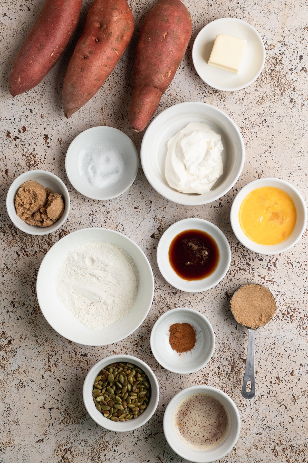 ingredients in small white dishes to make sweet potato casserole.