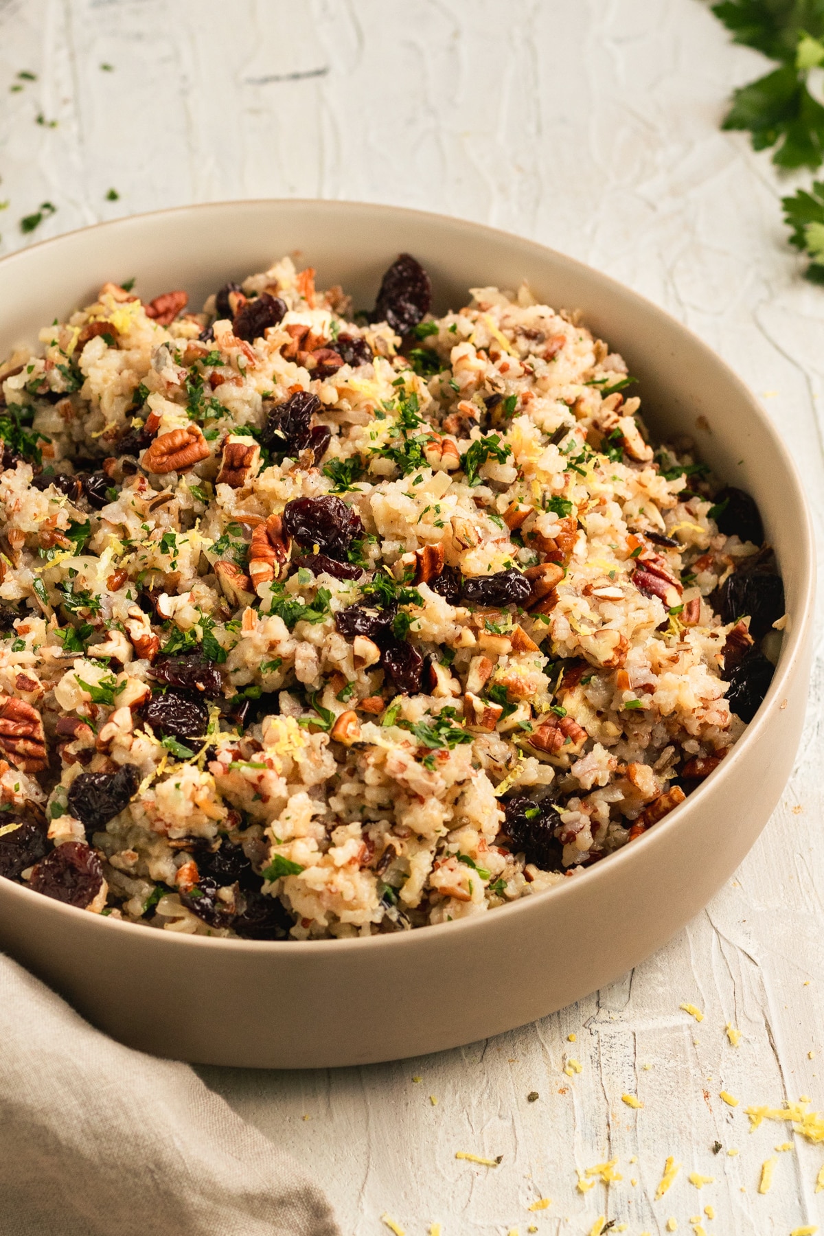 rice in a bowl garnished with dried cherries, lemon zest, and fresh parsley. 