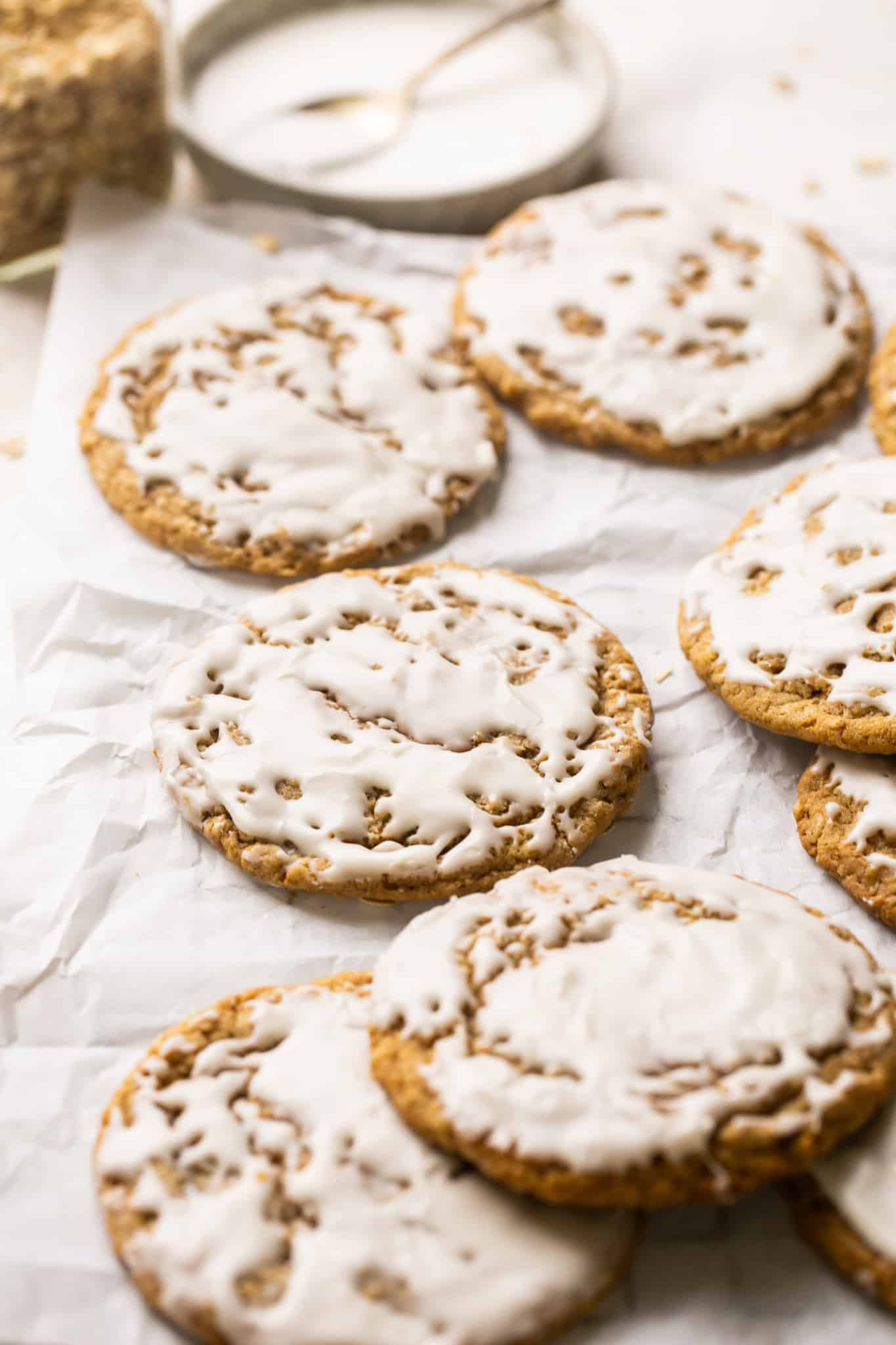 iced oatmeal cookies on parchment paper. 