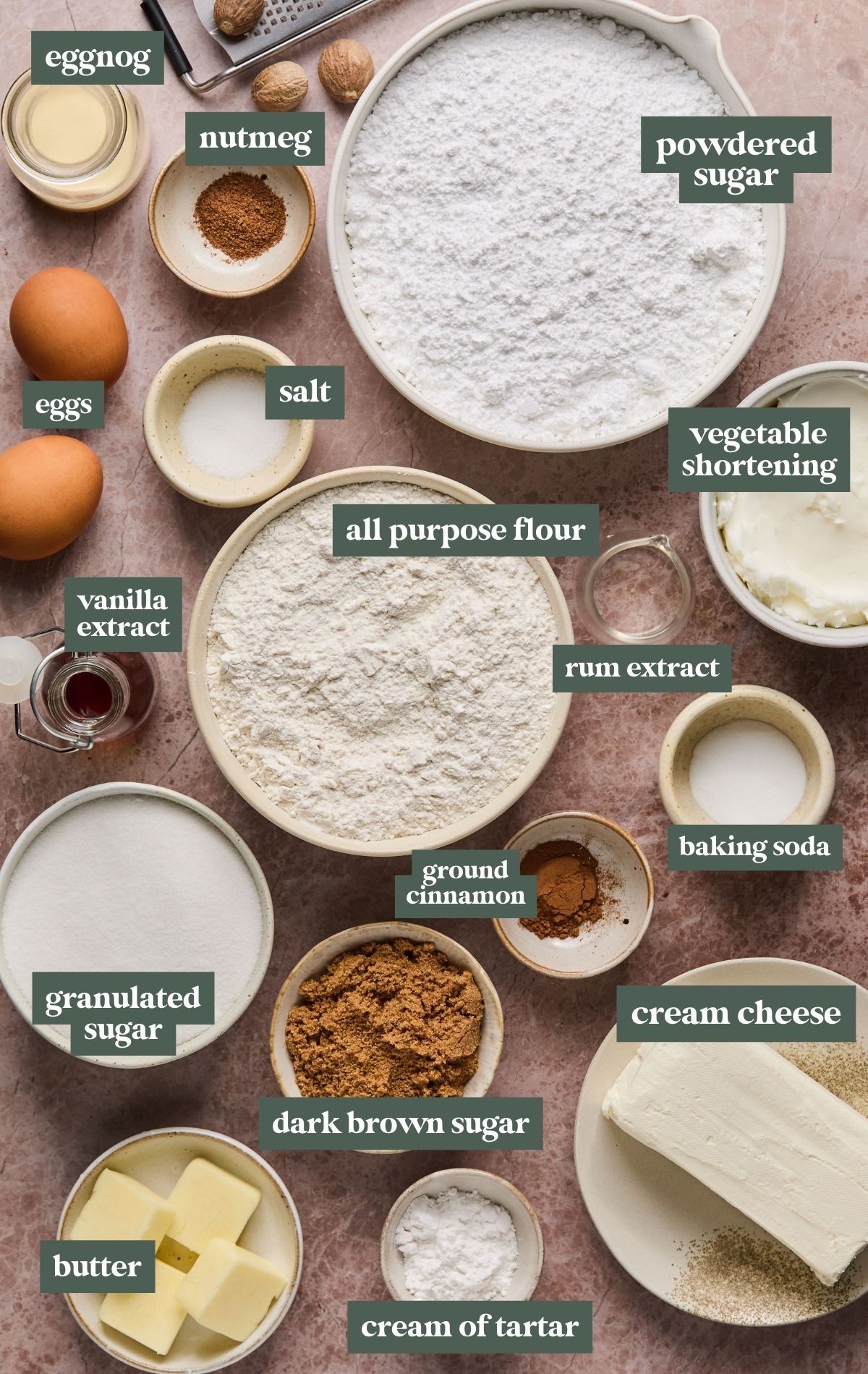 Ingredients needed to make eggnog cookies and cream cheese frosting in bowls with text identifying each item.