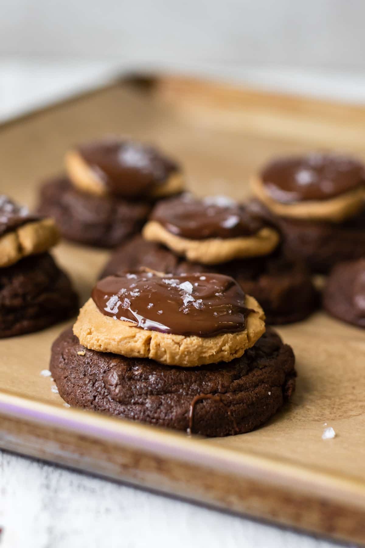 cookies on a baking sheet topped with peanut butter and chocolate.