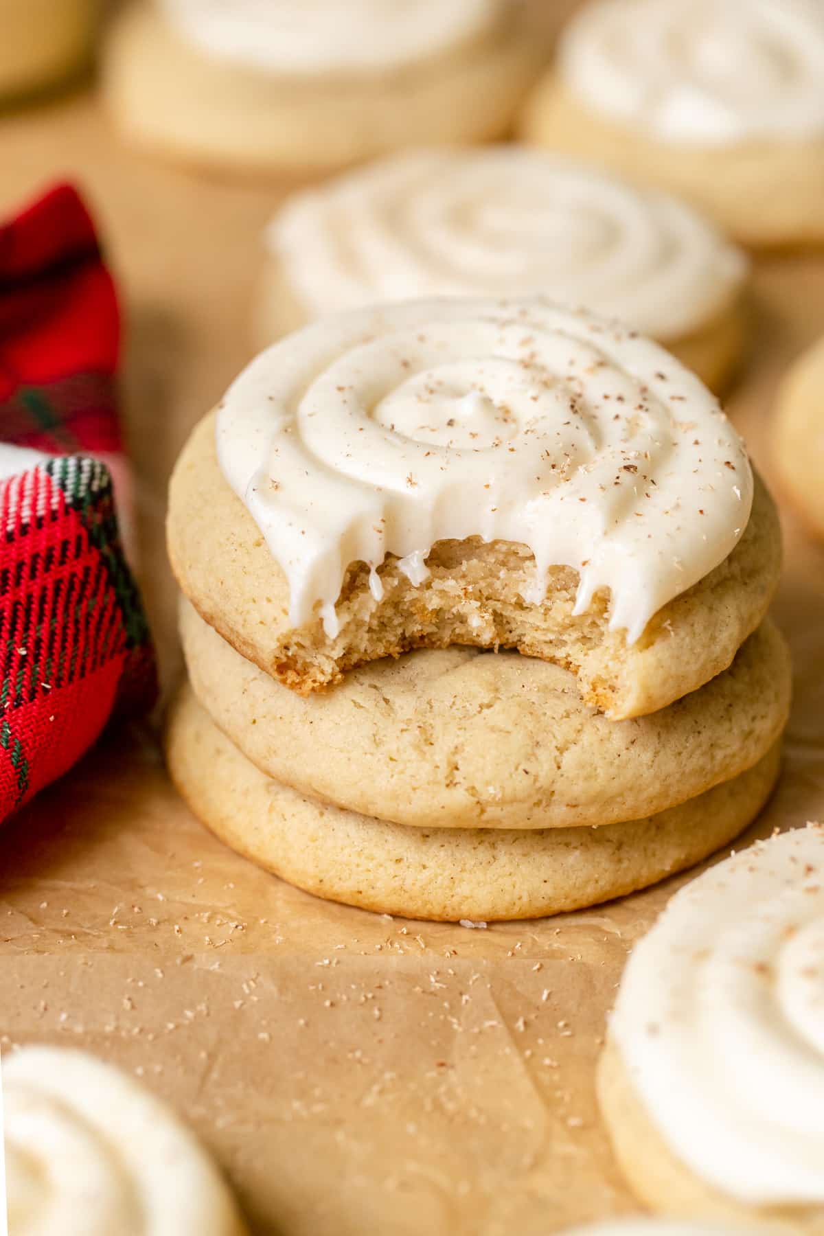 cookie with cream cheese frosting on top with a bite taken out of it. 