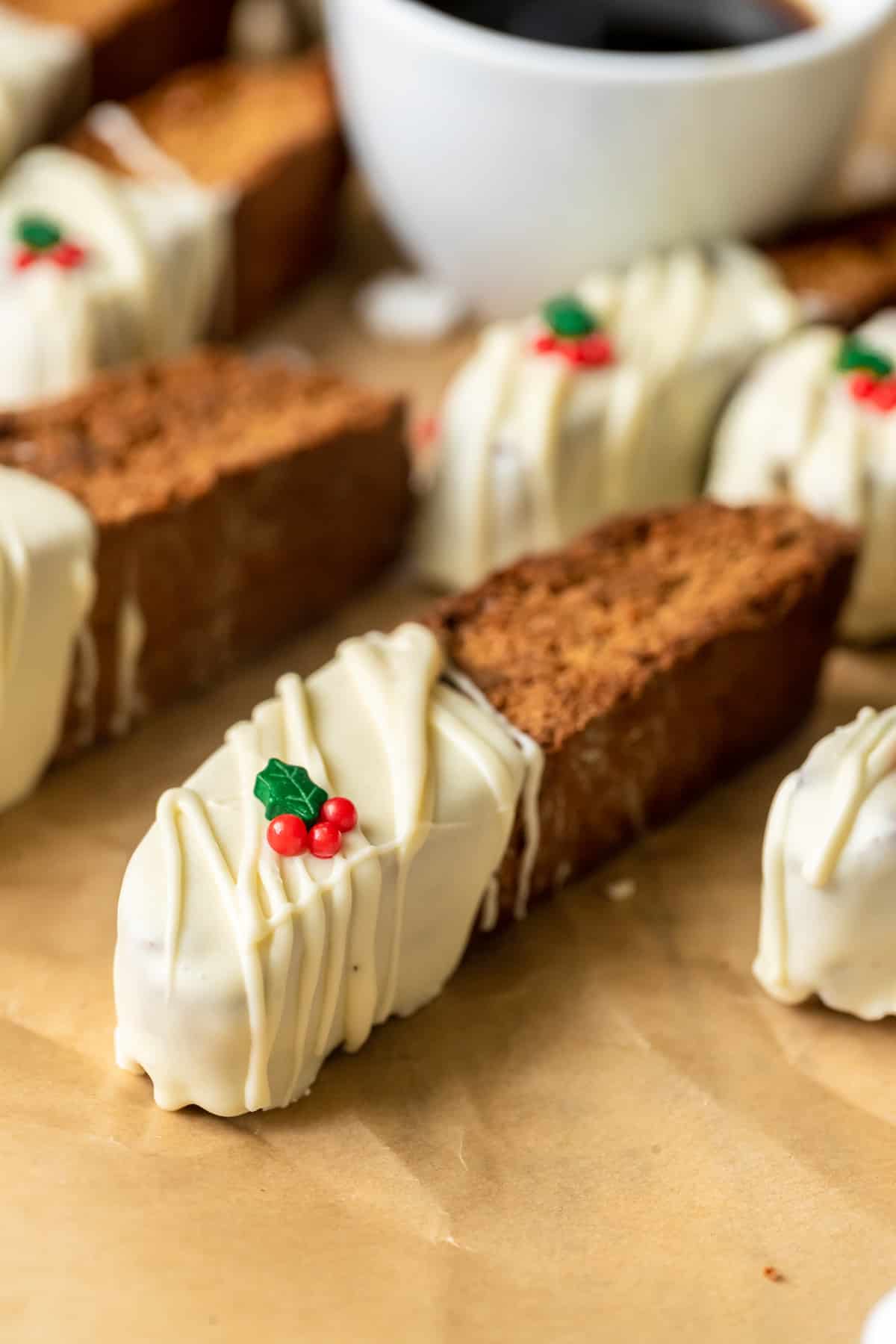 biscotti dipped in white chocolate with holly sprinkles on top. 