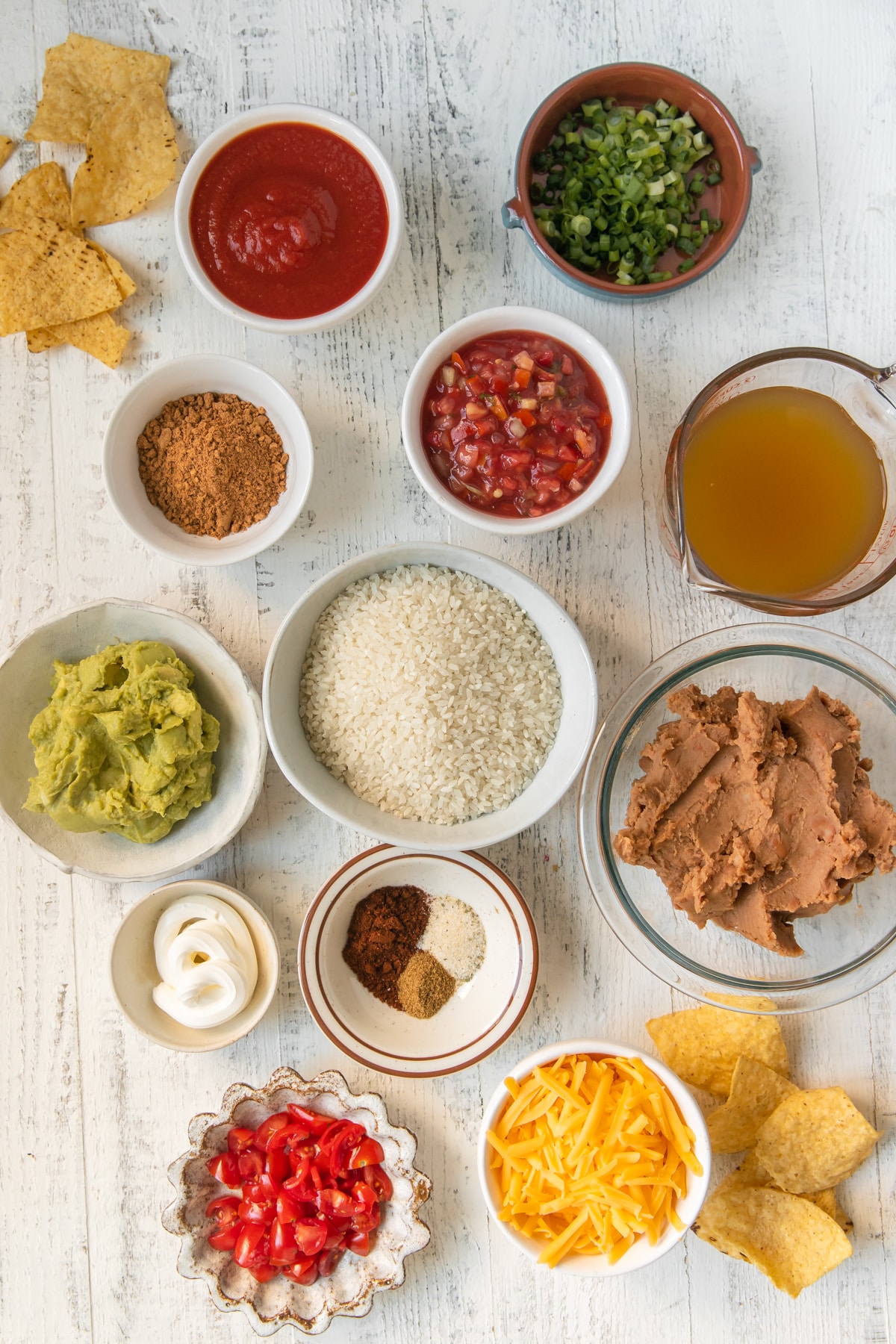 ingredients to make seven layer bean dip in individual bowls. 