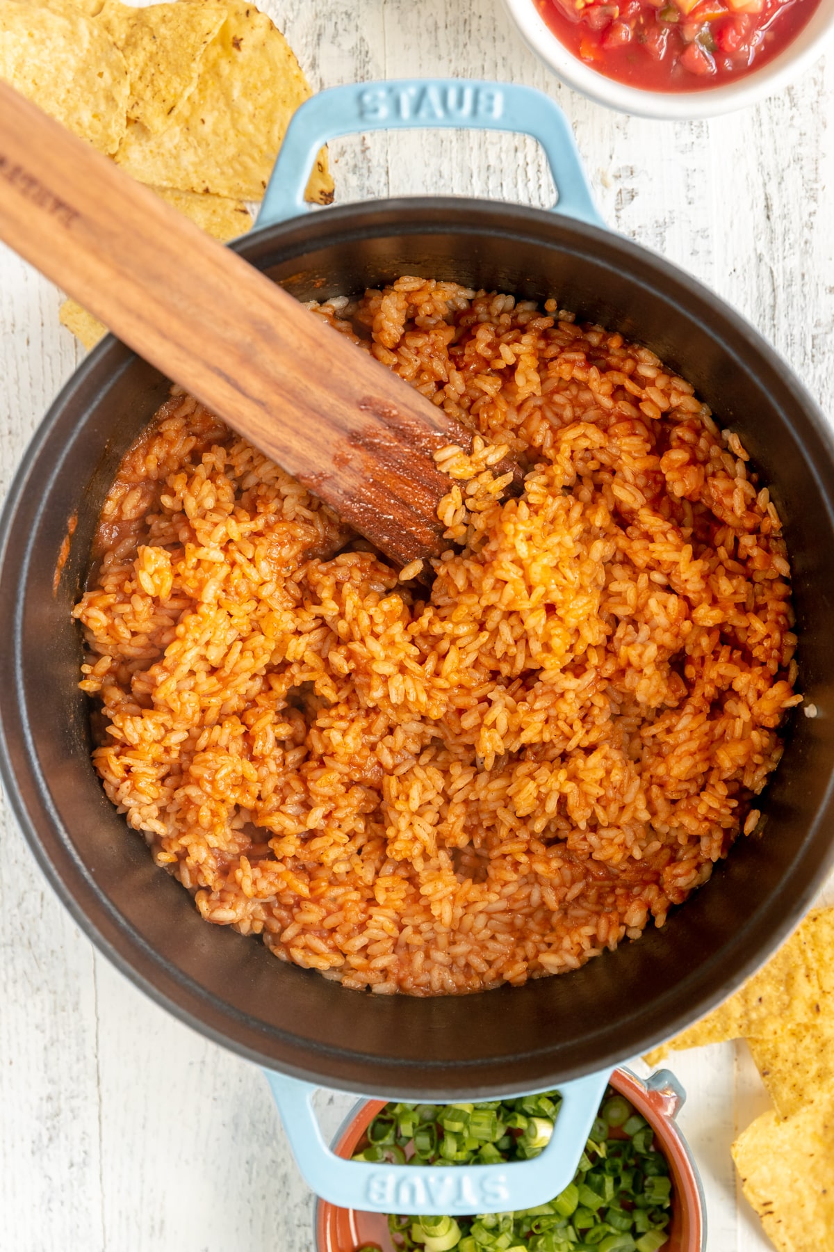 mexican rice in a pot with a wooden spoon in it. 