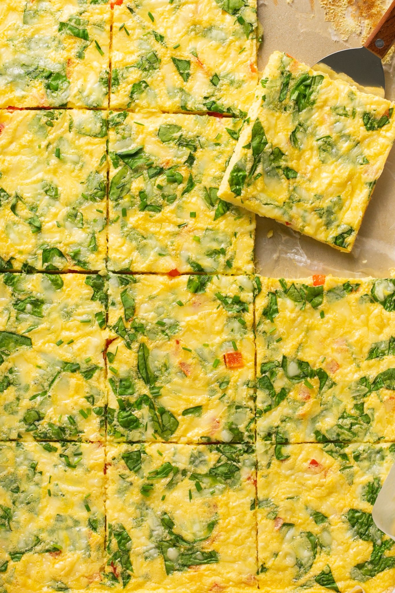 an up close image of sheet pan eggs cut into squares. 