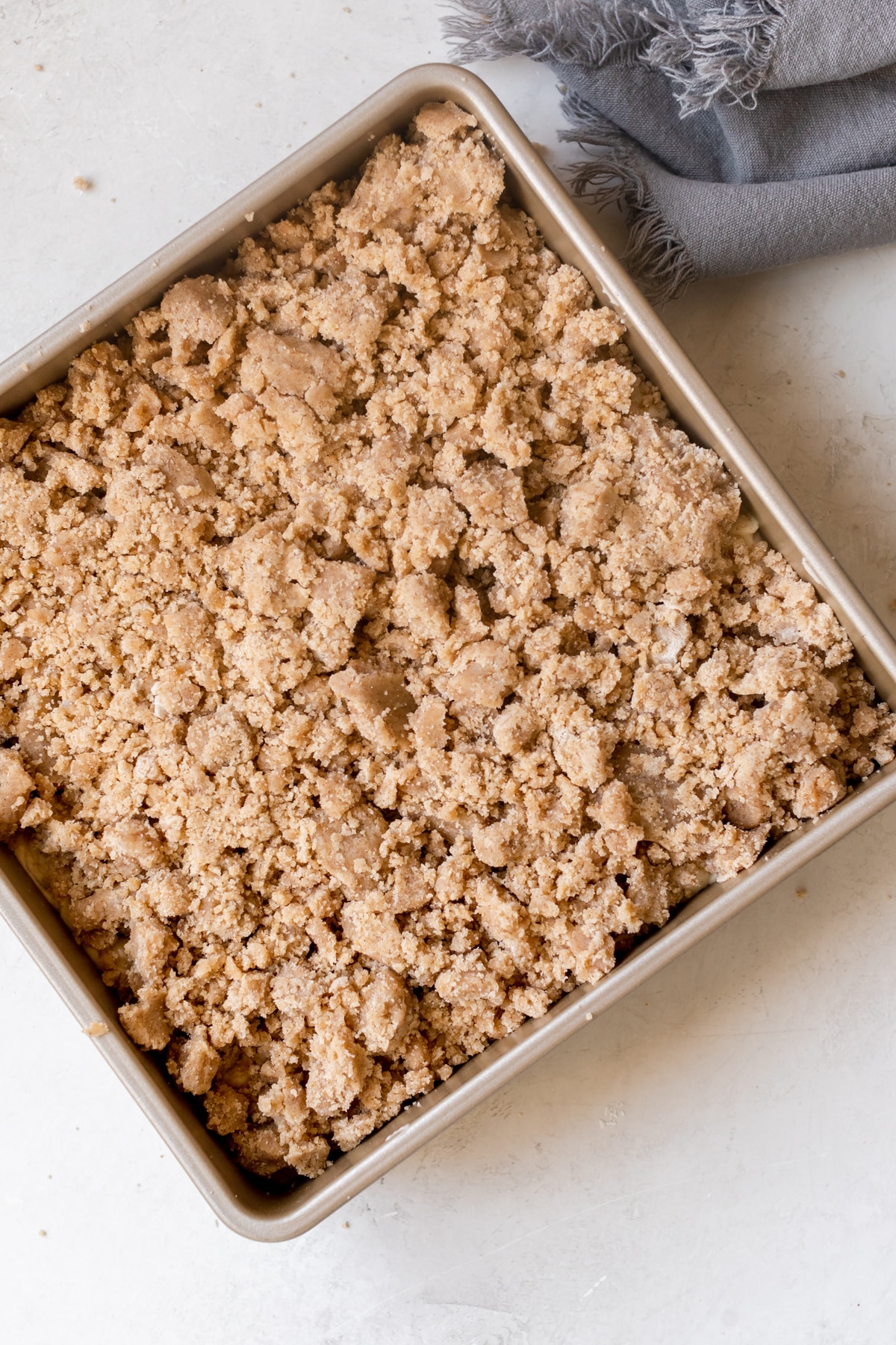 crumb cake about to head into an oven in a 9x9 pan. 