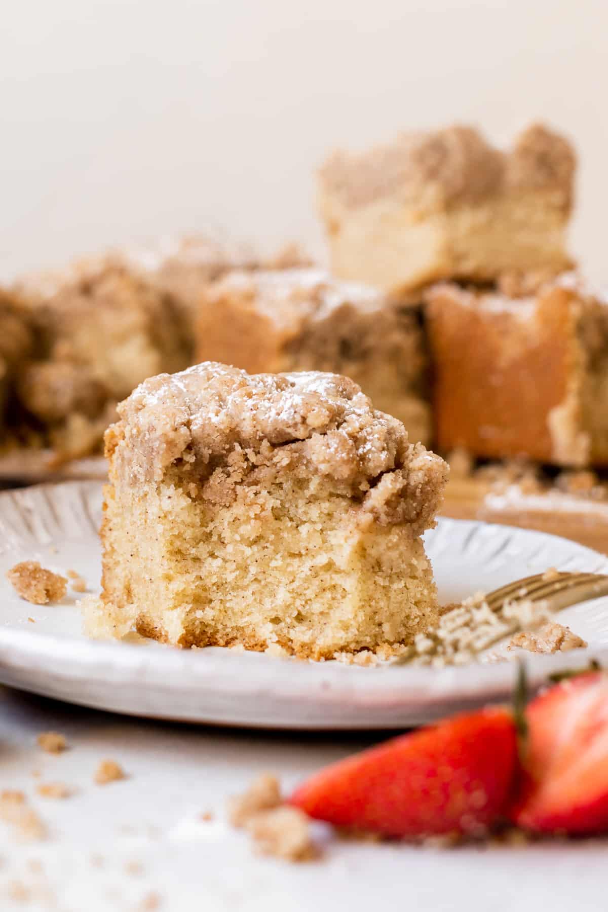 a bite taken out of crumb cake on a plate. 