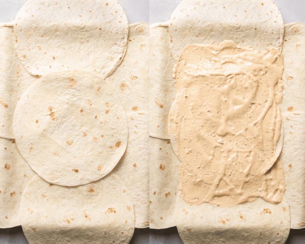 assembling quesadillas on a sheet pan with sauce spread on top of flour tortillas. 