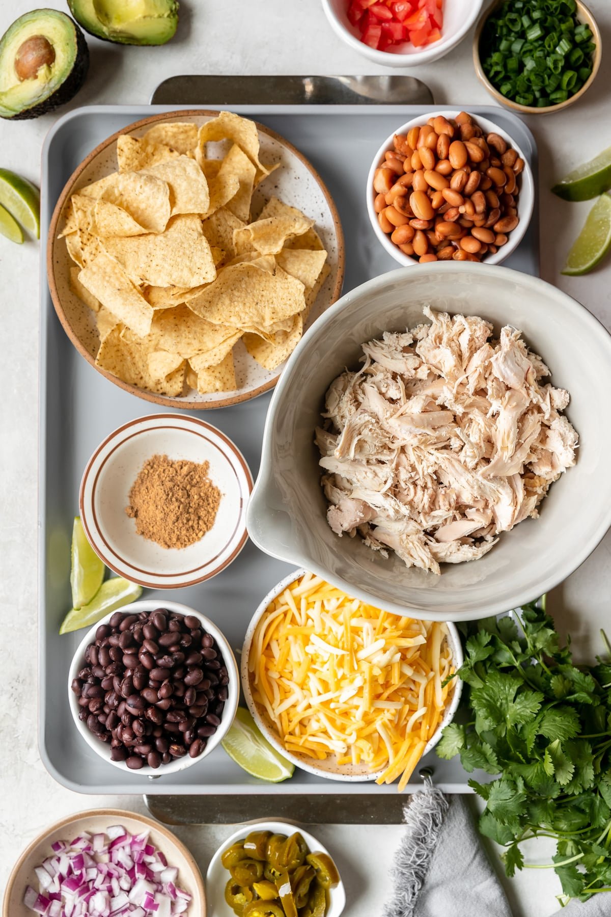 ingredients to make nachos in small bowls. 