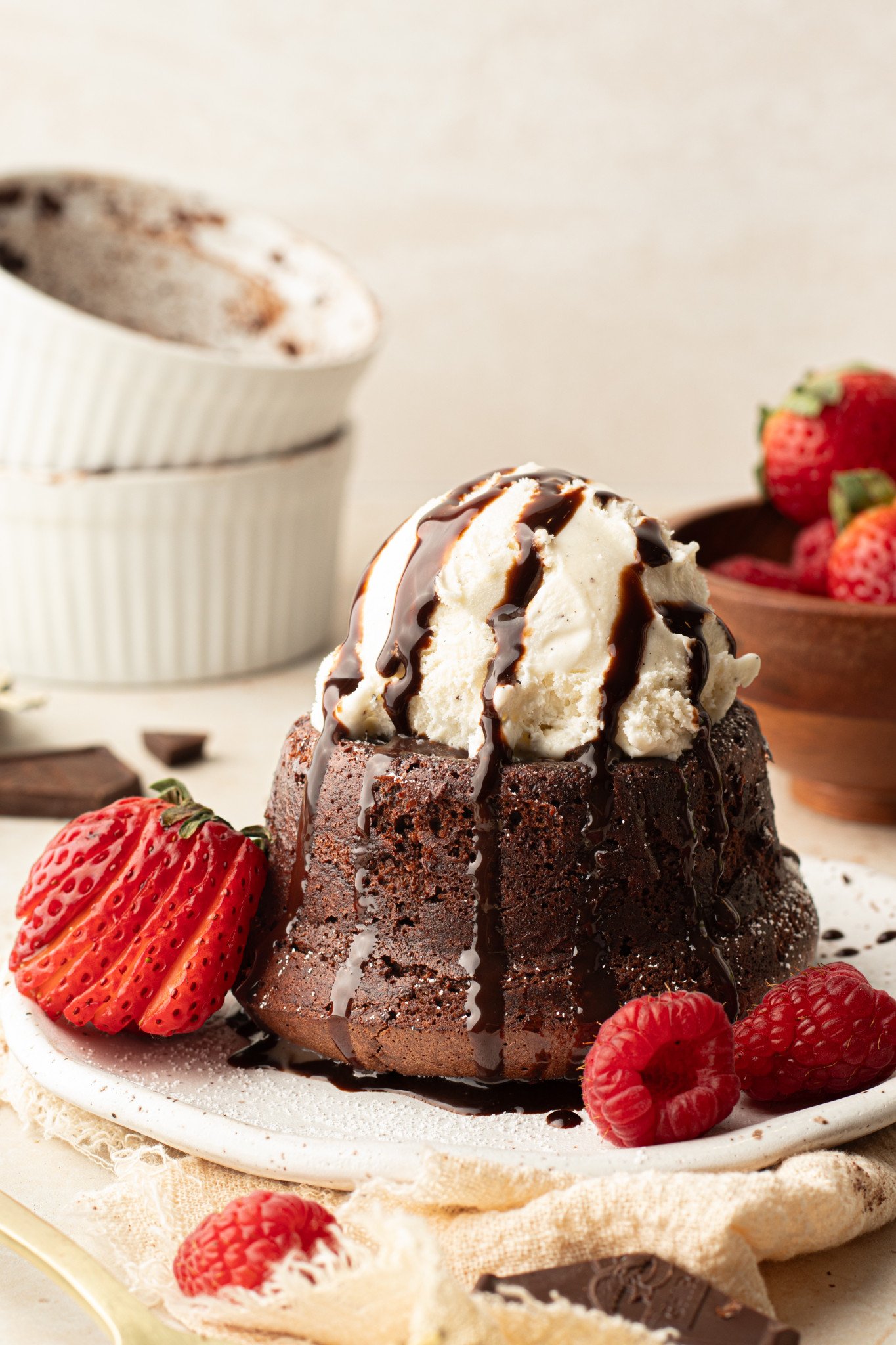 an image of chocolate molten cake with ice cream and chocolate syrup on top. 