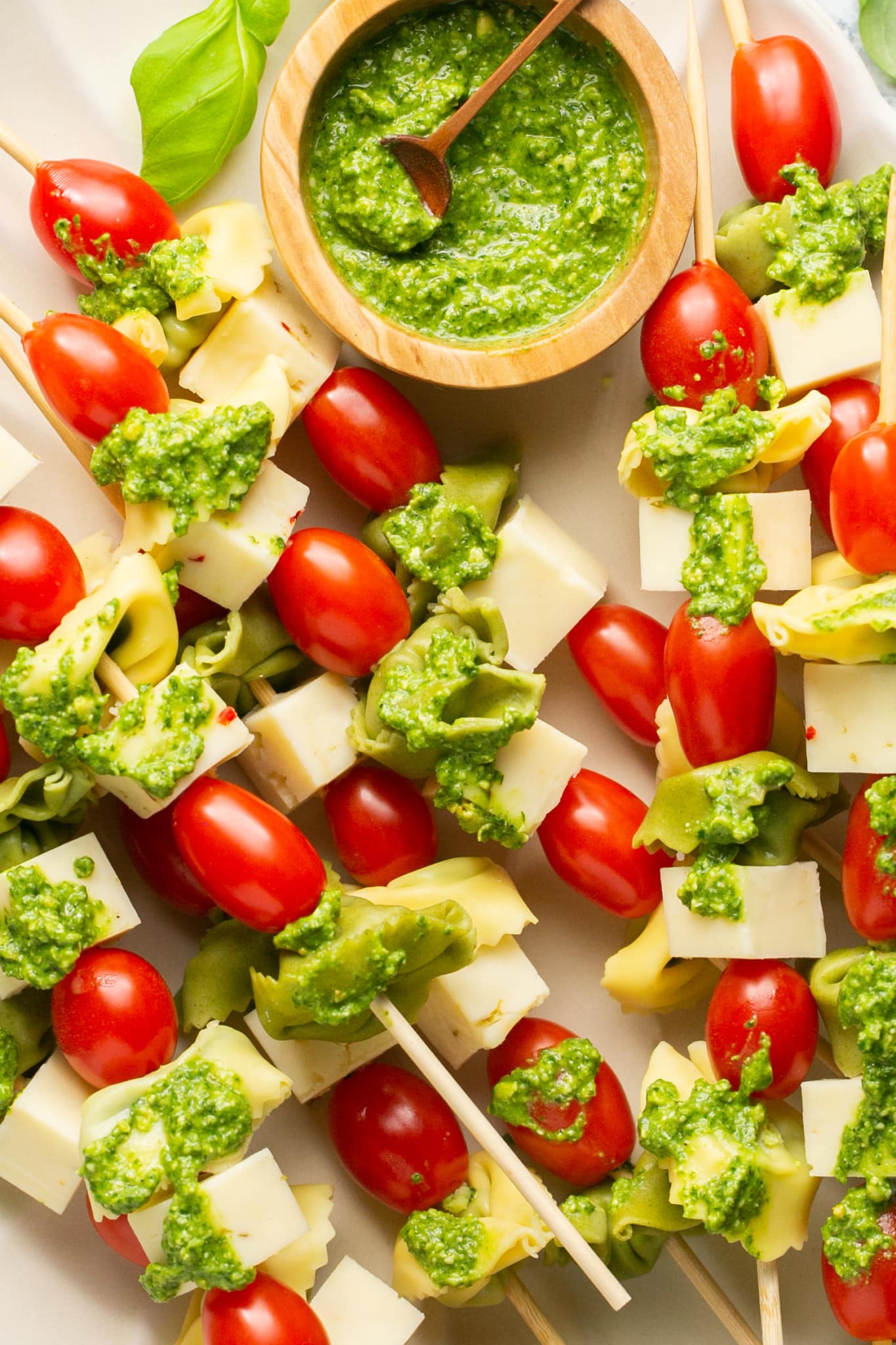 These Tortellini Skewers are made with cheese tortellini, cherry tomatoes, pepper jack cheese and served with a lemon spinach pesto for dipping. They are an easy party appetizer and are always a hit! #tortellini #partyappetizer #appetizerideas #easyappetizers #krollskorner #bbqsides #bbqideas #partysnacks 