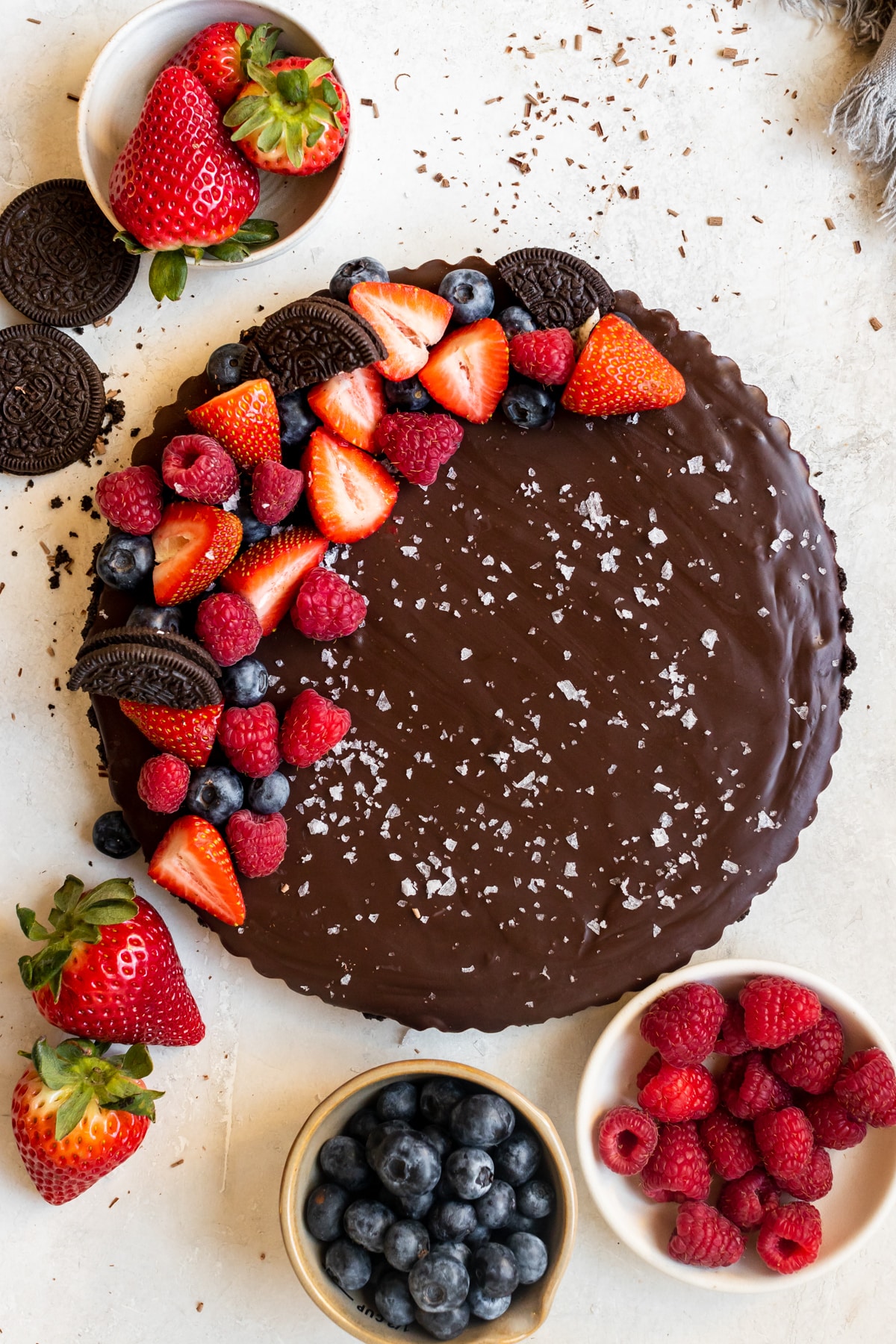 a tart made with oreo crust and chocolate filling topped with berries and flaky sea salt. 