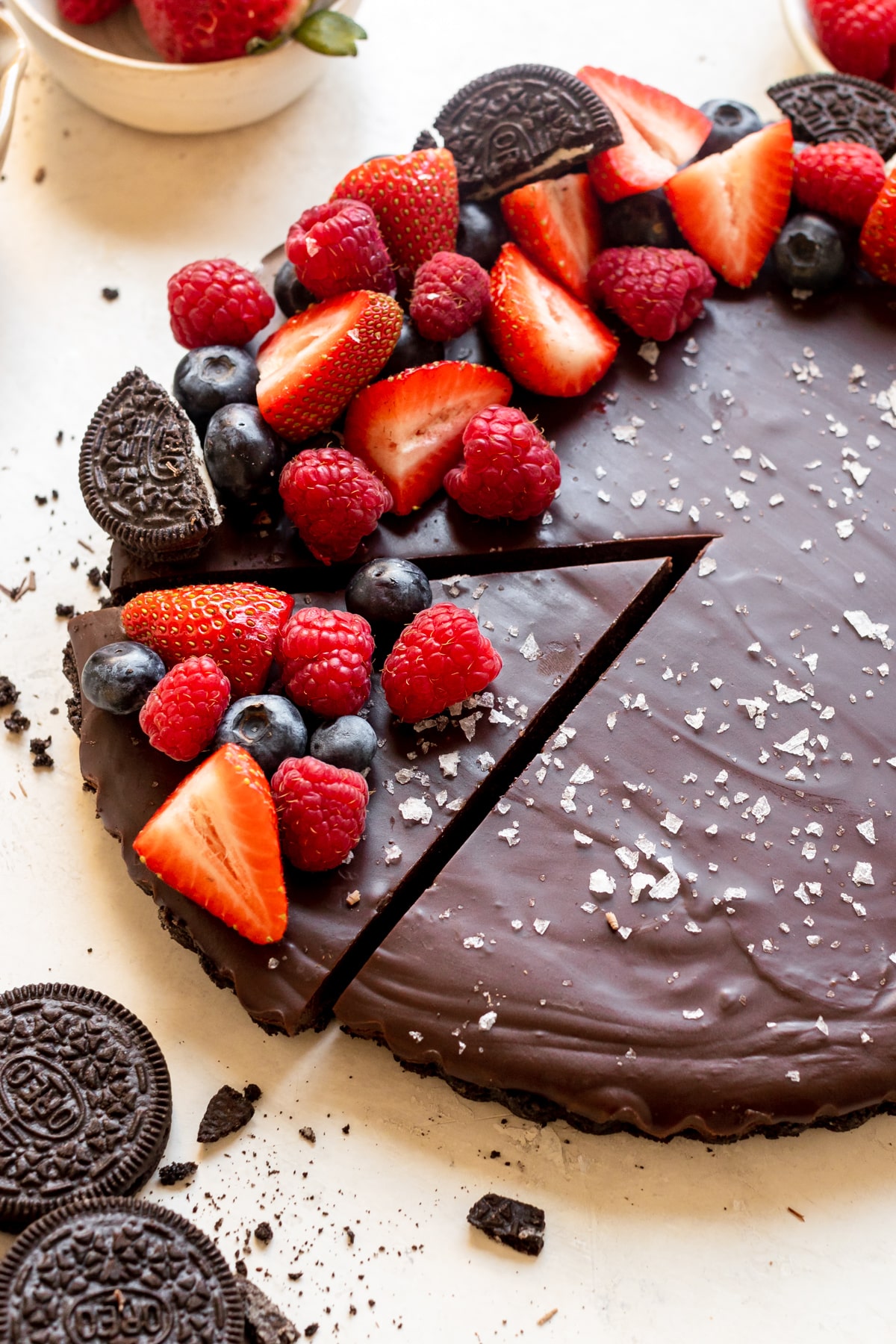 a tart made with oreo crust and chocolate filling topped with berries and flaky sea salt. 