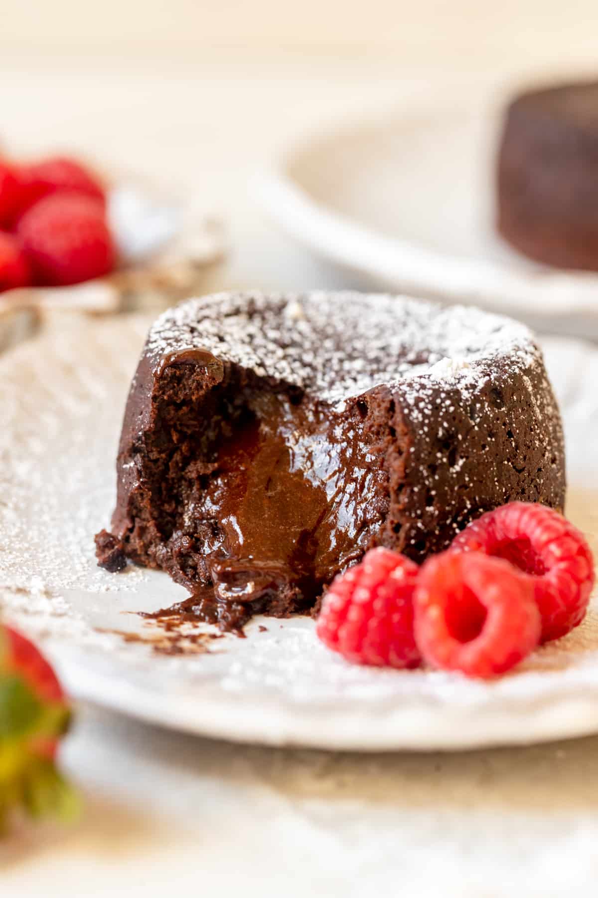 molten cake with a bite taken out of it on a white plate. 