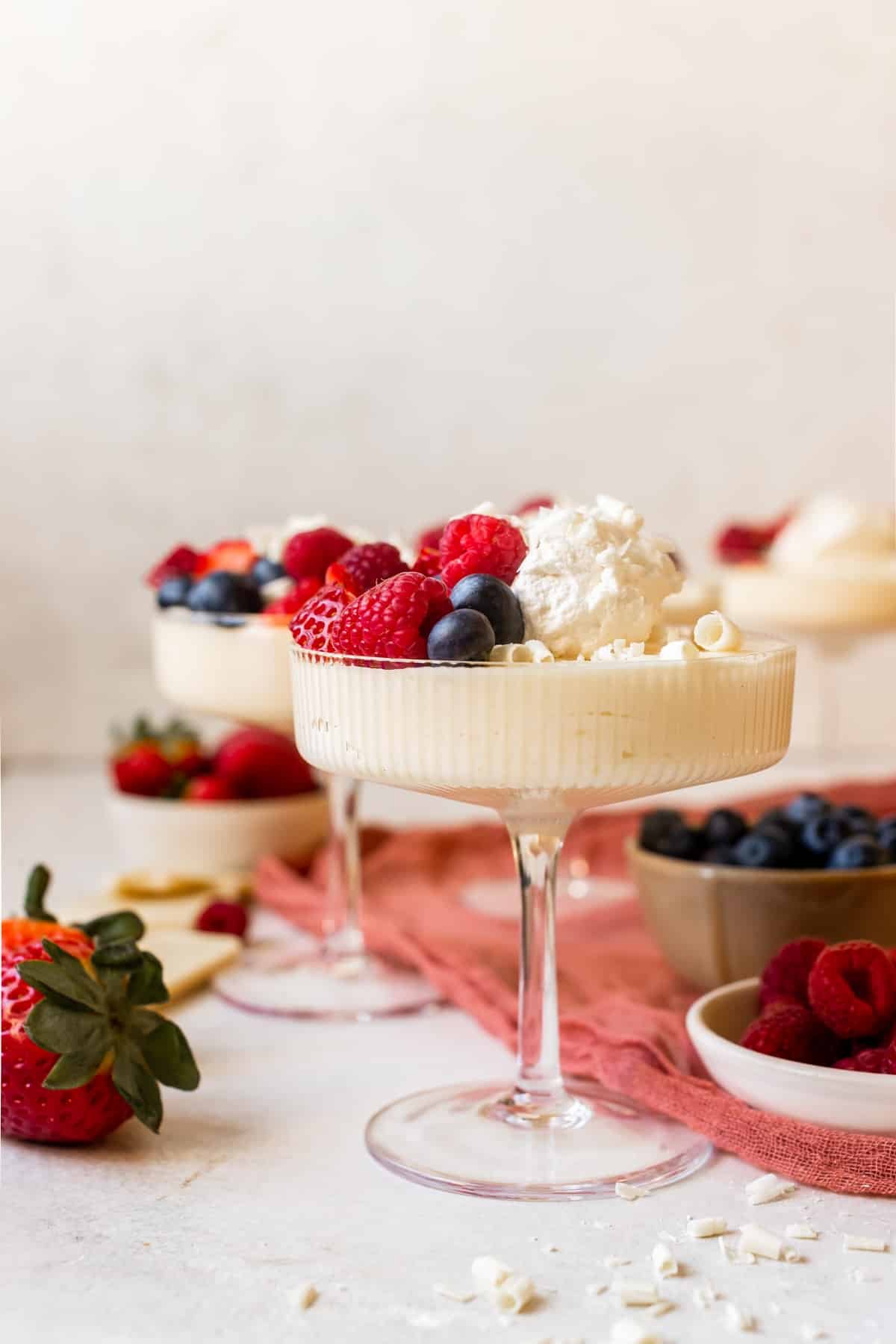 mousse in martini glasses topped with whipped cream and fresh berries. 