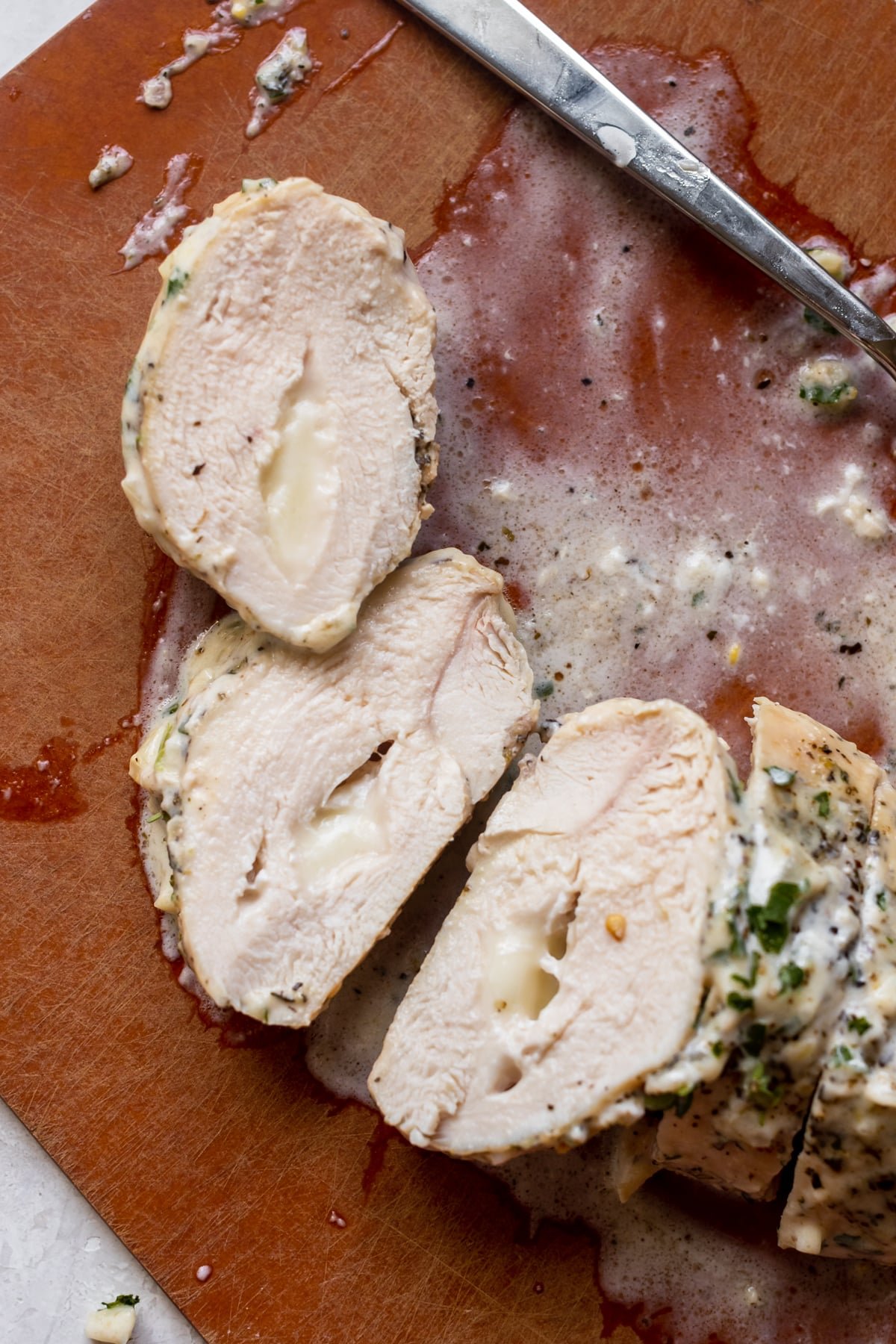 chicken on a cutting board stuffed with mozzarella cheese. 